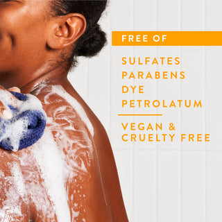 Person lathering in shower with text reading “Free of sulfates, parabens, dye, petrolatum, vegan & cruelty free”