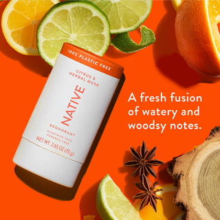 Native deodorant with text saying "A fresh fusion of watery and woodsy notes", styled with wood pieces, lemon and orange slices