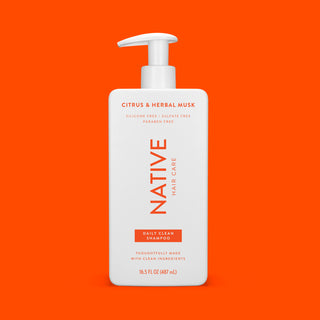 Front of Citrus & Herbal Musk Daily Clean Shampoo bottle on red background