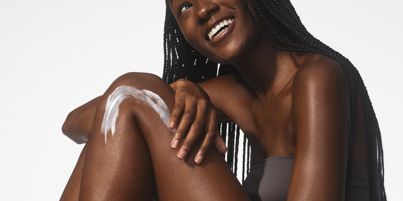 A smiling woman with braided hair applies Native body lotion to her damp skin, illustrating why moisturizing immediately after a shower boosts hydration and how glycerin works, answering "When should you use body lotion" for optimal results