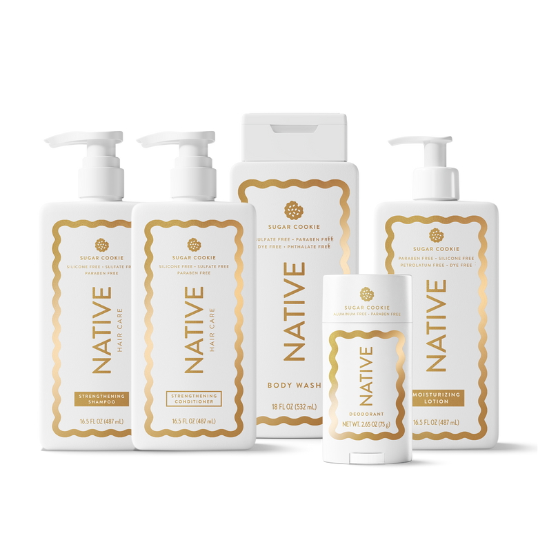 A set of Native Holy Care personal care products in a clean white studio setting, including body wash, moisturizer, body wash pump bottles, a deodorant stick, and a body wash box, all with white packaging and gold labels.
