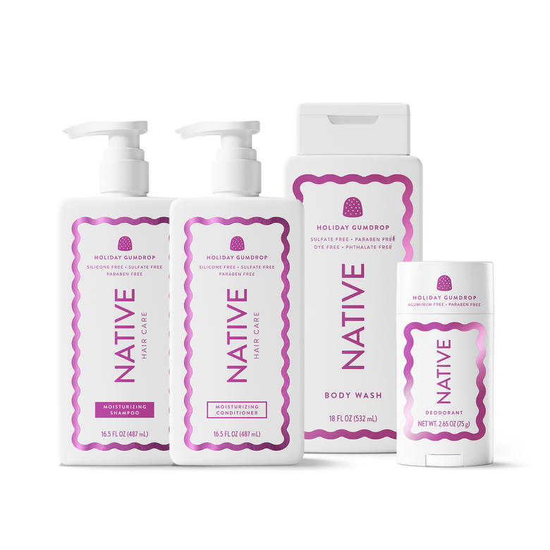 A set of Native Hair Care Holiday Gumdrop products including shampoo, conditioner, body wash, and deodorant in white containers with pink and purple labels, arranged on a white background.