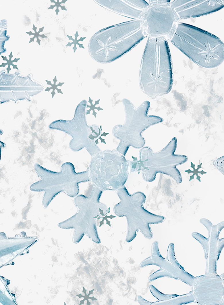 A close-up of a white surface decorated with translucent light blue ice-like snowflakes and small snowflake motifs.