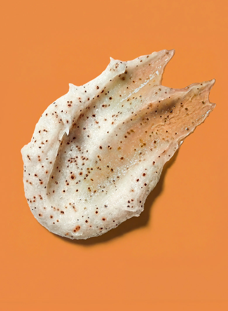 A single irregular, translucent white product smear for Maple Latte Body Scrubs with small brown speckles, photographed on a solid orange background.