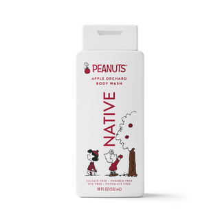 A white rectangular bottle of Peanuts Apple Orchard Body Wash with a flip-top cap. The label features red text reading 'PEANUTS' and 'BODY WASH' with 'NATIVE' printed vertically in red.