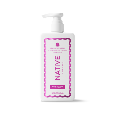 A white plastic pump bottle of Native Hair Care Holiday Squidrop Moisturizing Shampoo, featuring a pink and purple label, on a clean white background.