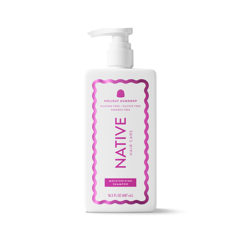 A white plastic pump bottle of Native Hair Care Holiday Squidrop Moisturizing Shampoo, featuring a pink and purple label, on a clean white background.