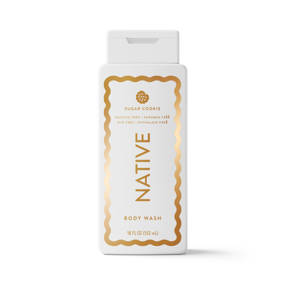 An 18 fl oz bottle of Native Body Wash in the Sugar Cookie scent, featuring a white bottle with a gold decorative border and gold lettering, set against a clean white background.