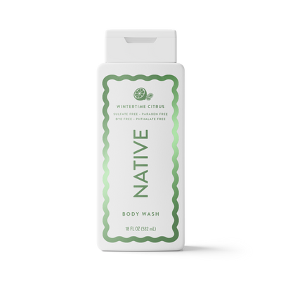 A white plastic bottle of Native Wintertime Citrus body wash with a white cap, featuring a green wavy border and text on the front label, set against a plain white background.